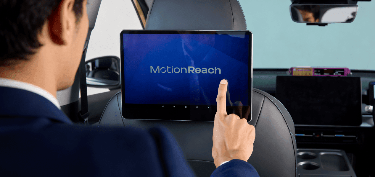 Passenger tapping an interactive MotionReach digital screen in a Bangkok taxi