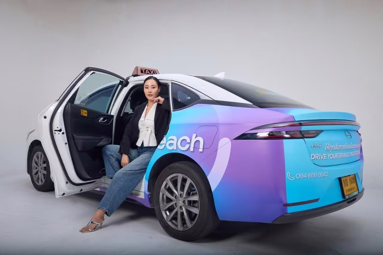 MotionReach-wrapped EV taxi in Bangkok with a passenger stepping out