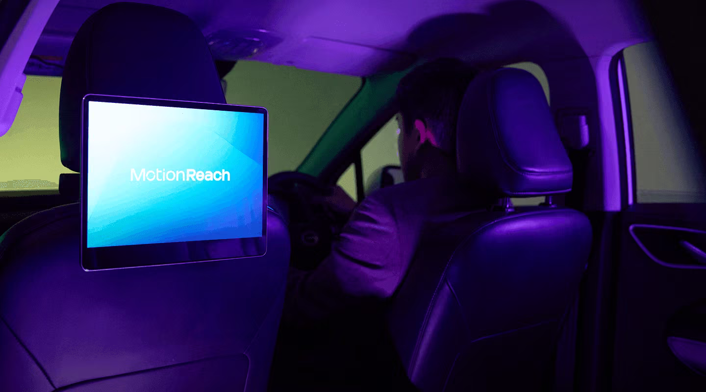 Digital screen mounted on a taxi headrest playing a MotionReach advertisement
