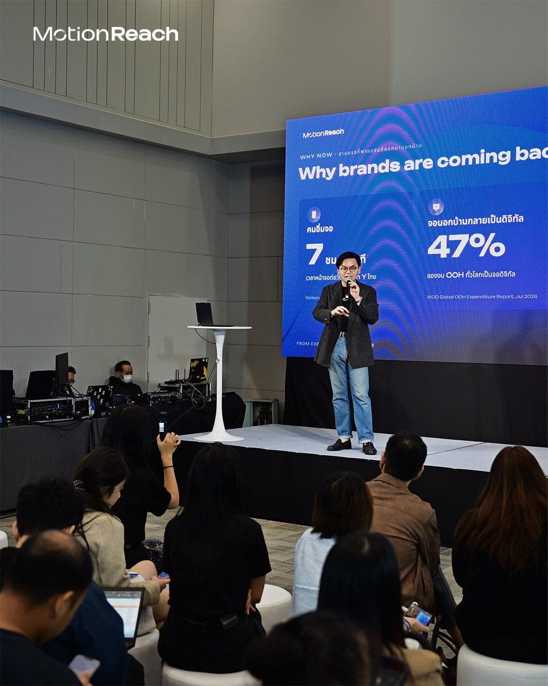 MotionReach speaker presenting why brands are coming back to out-of-home to a seated audience
