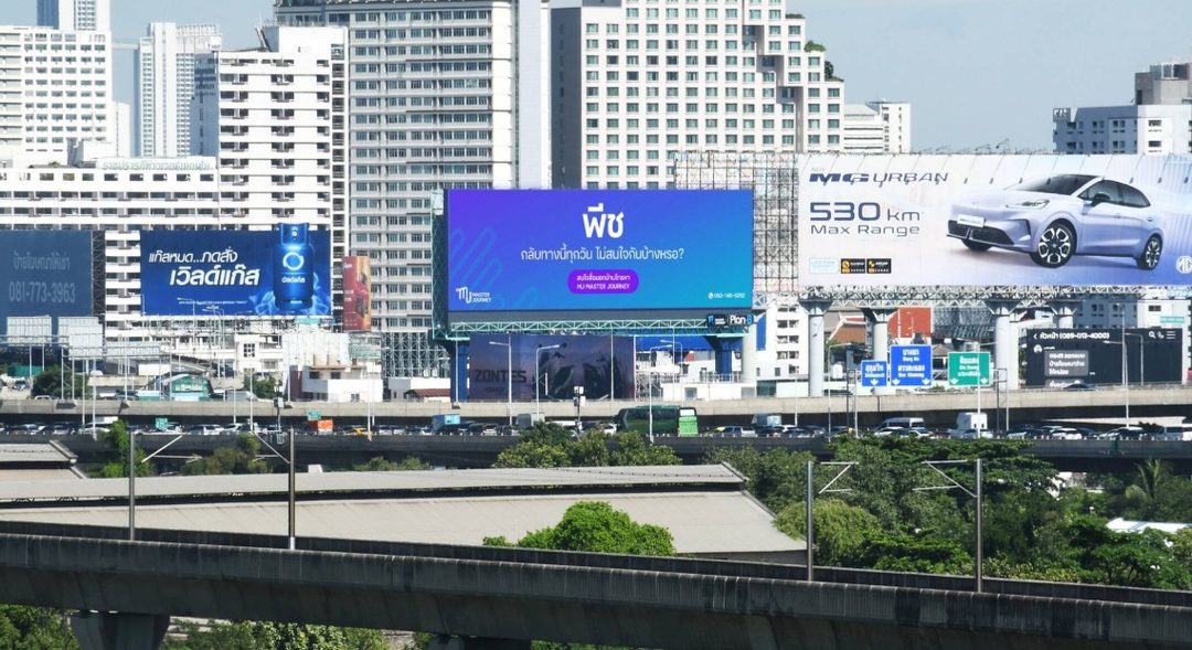 One Eyeball Billboard addressing an executive by the nickname Peach beside a Bangkok expressway
